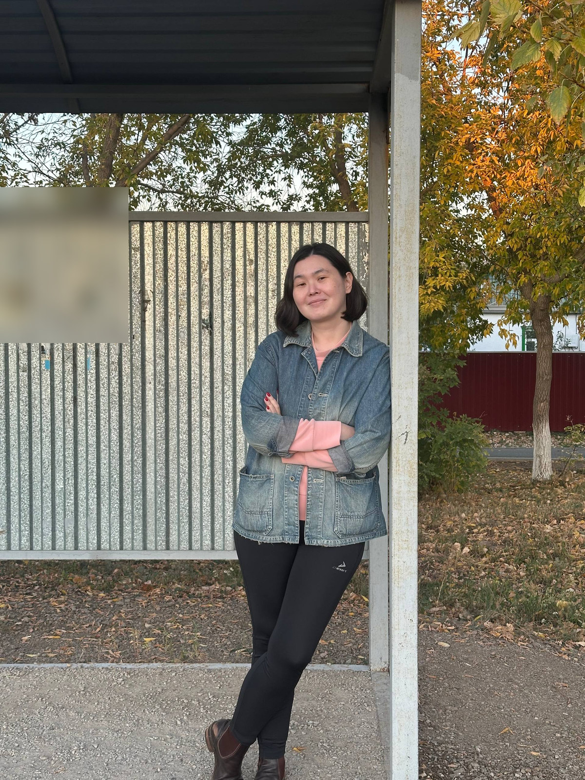 A member of the team leaning on a bus-stop post