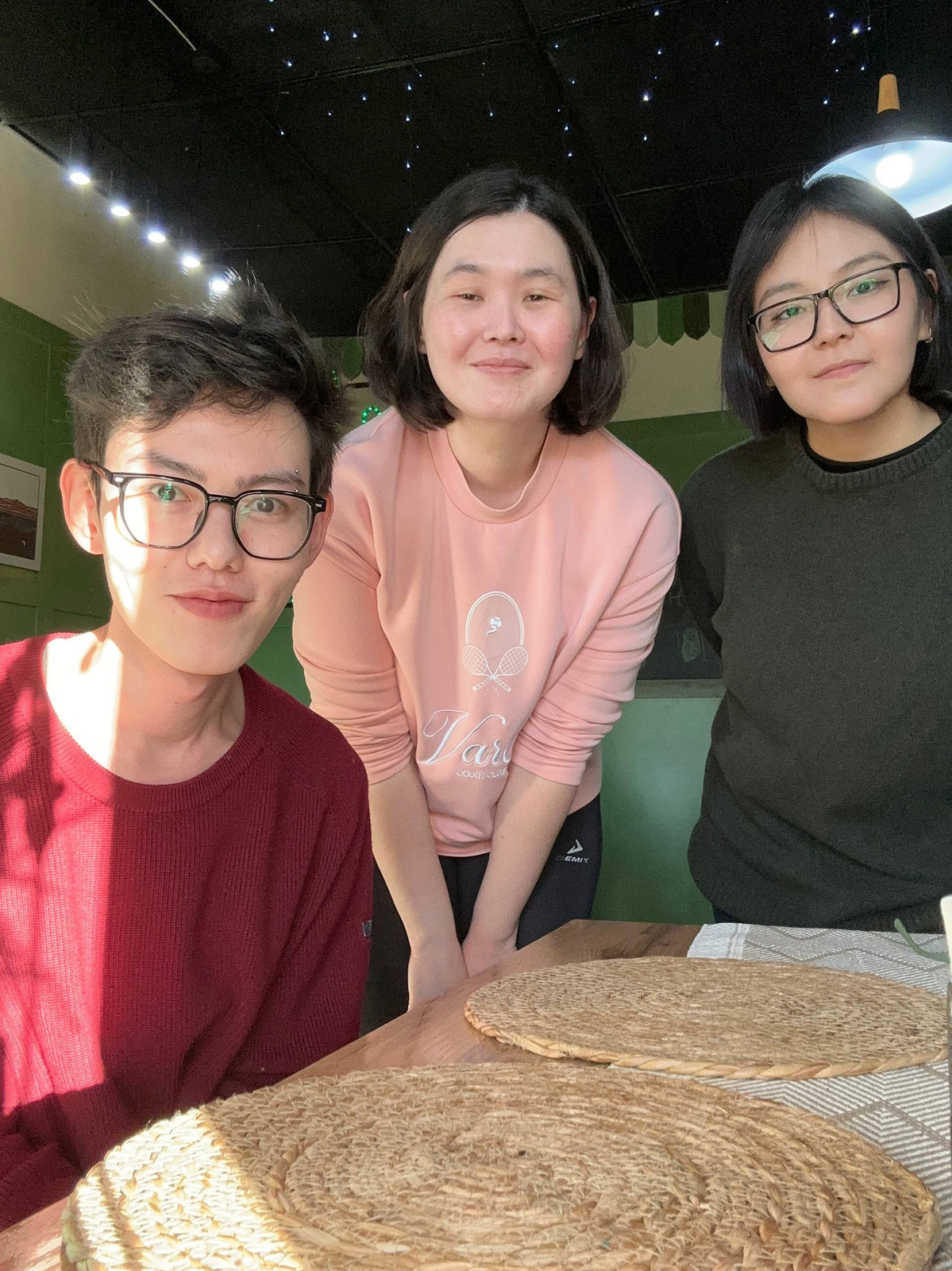 Three members of the team in a café, smiling at the camera