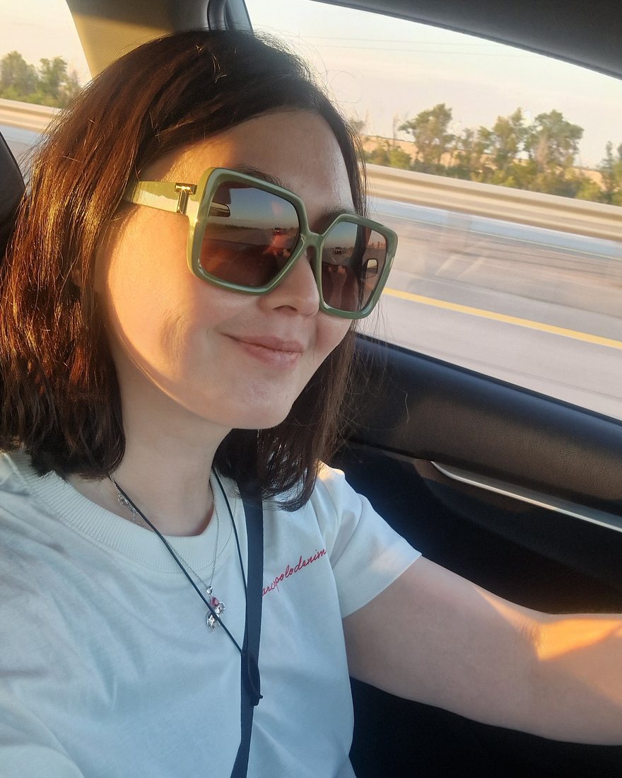 Dina Pisareva in a car on the road, August 2026